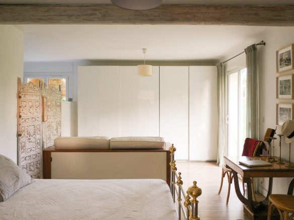 Interior of an Art Deco house with bed, storage unit and desk.