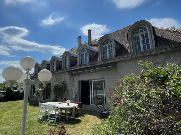 Maison individuelle de 12 pièces avec jardin à Roissy-en-Brie sous un ciel ensoleillé.