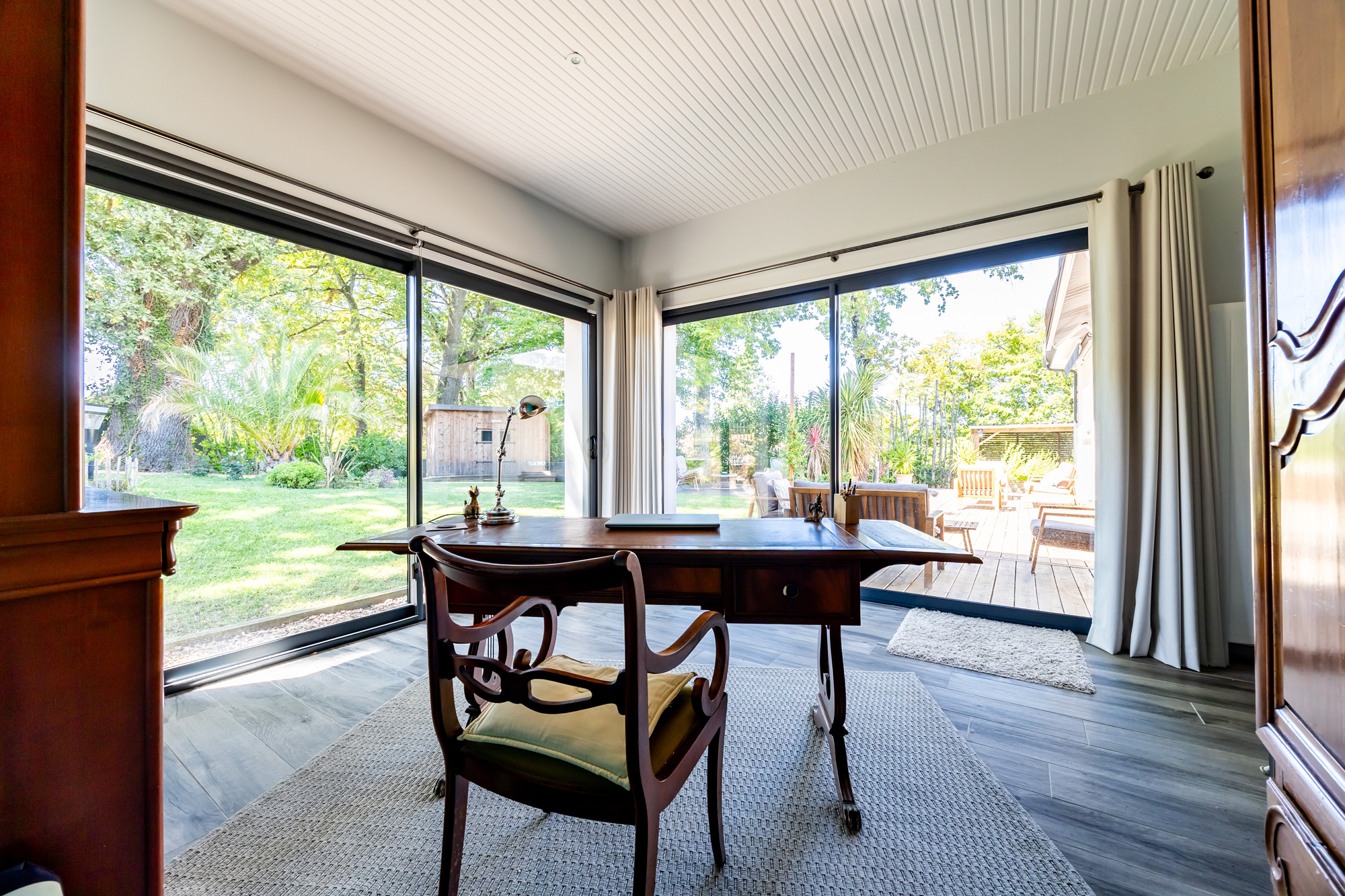 Maison de plain pied à Eysines Intérieur d'une maison de plain pied avec un bureau et de grandes fenêtres donnant sur le jardin.