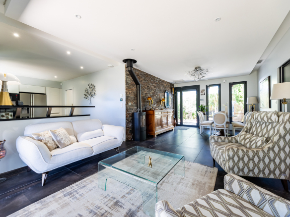 Intérieur d'une maison de plain pied moderne avec salon lumineux et cuisine ouverte.