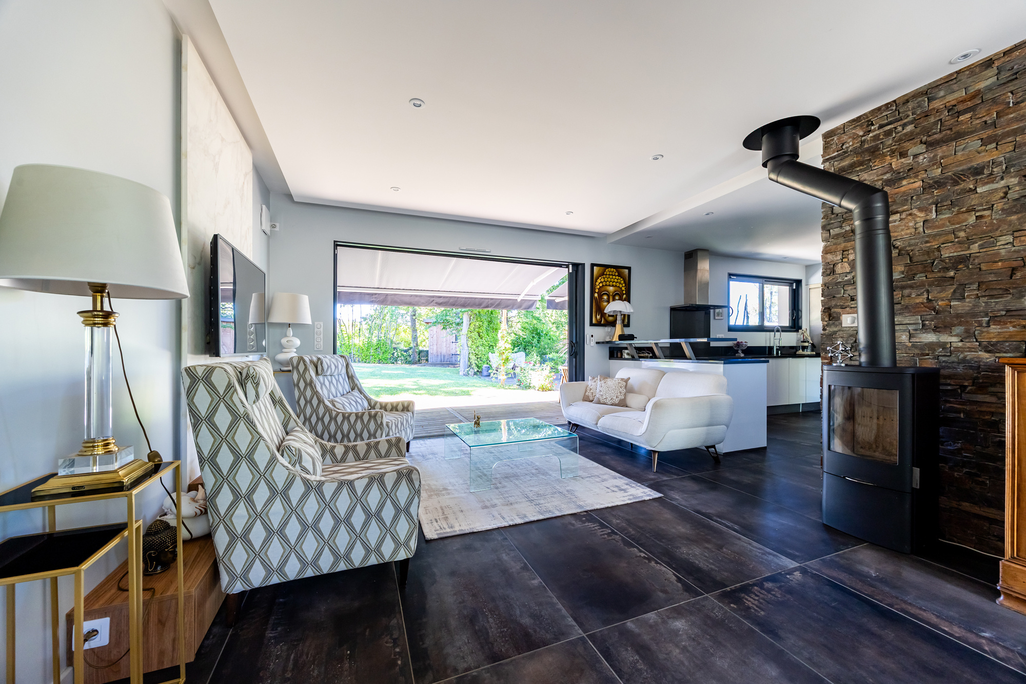 Intérieur d’une maison moderne à Eysines Intérieur d'une maison de plain pied moderne avec salon lumineux et cheminée, jardin visible à travers les baies vitrées.
