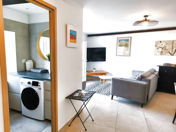 Intérieur d'un duplex rénové à Bonnieux, montrant un salon moderne et une cuisine ouverte.