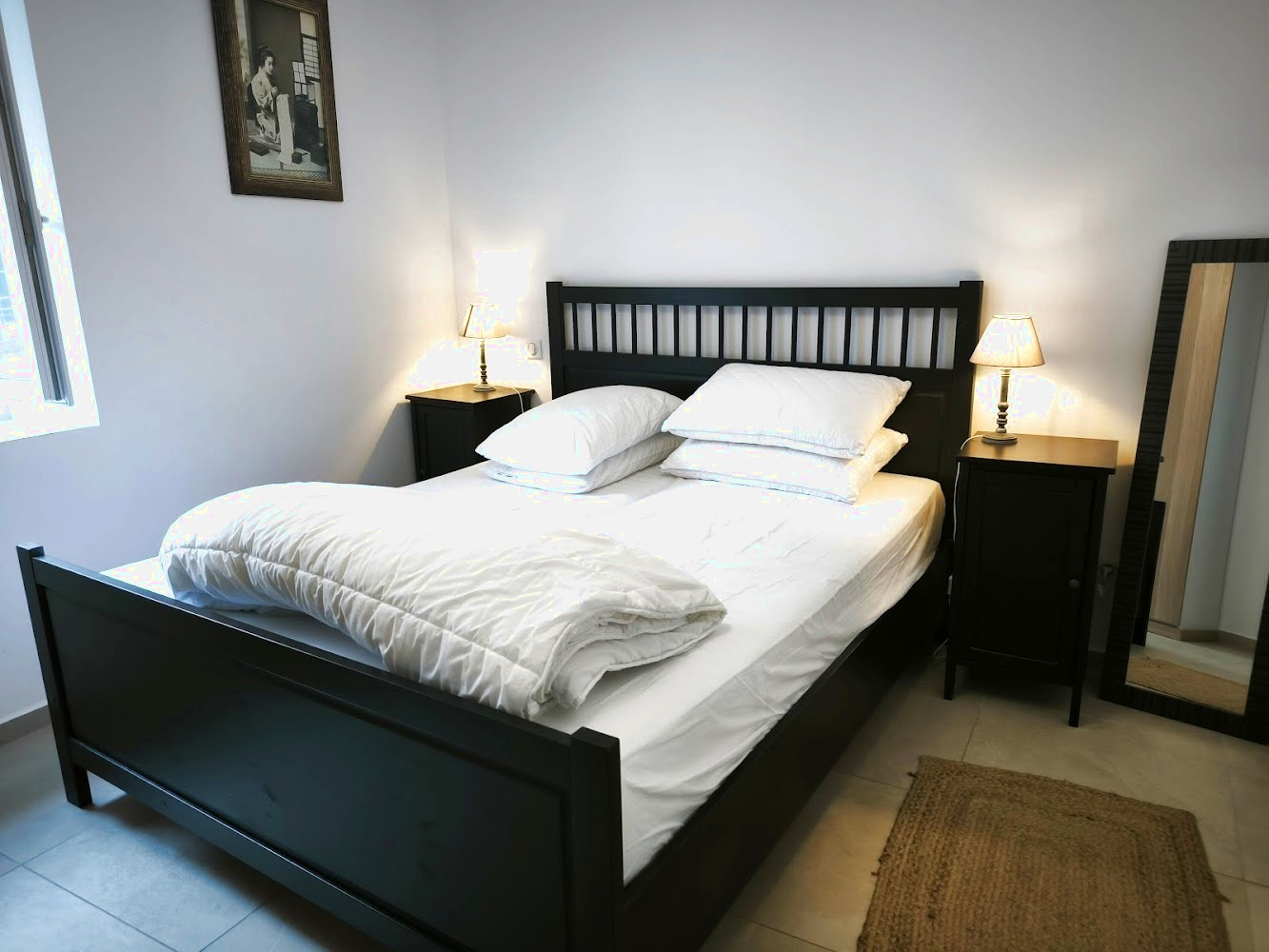 Chambre d’un duplex à Bonnieux Chambre à coucher avec lit double, tables de nuit et lampes dans un appartement rénové à Bonnieux.