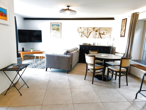 Intérieur d'un duplex moderne à Bonnieux avec salon, table à manger et télévision.