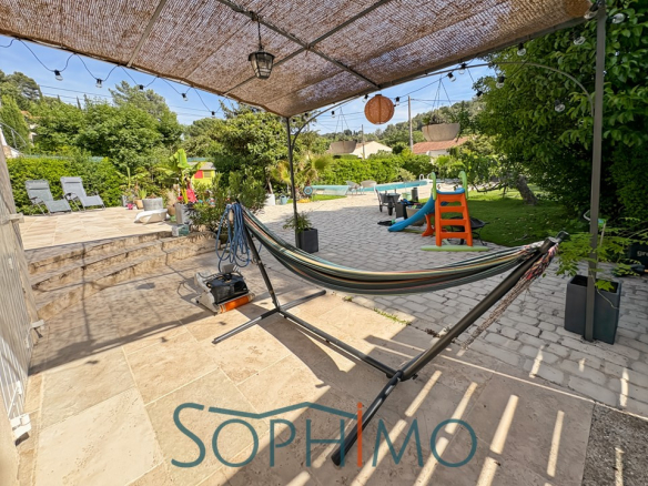 Terrasse en pierre avec hamac, jardin paysagé et piscine, quartier calme à Aix-en-Provence.