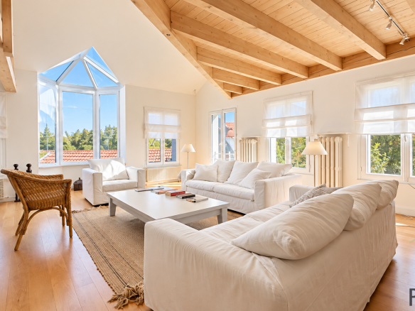 Interior of a stone house with a bright living room and high windows.