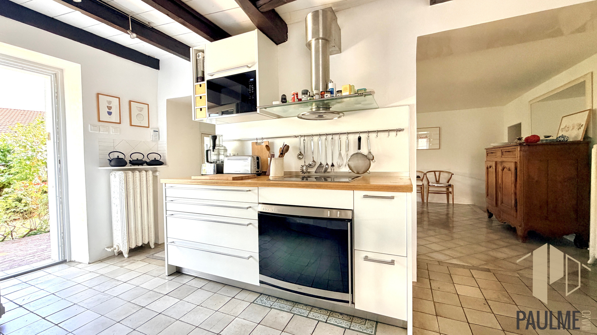 Kitchen of a house in Sergy Modern and bright kitchen in a stone house in Sergy, with white furniture and a wooden worktop.