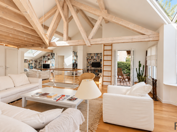Interior of a stone house with exposed beams and a bright living room.