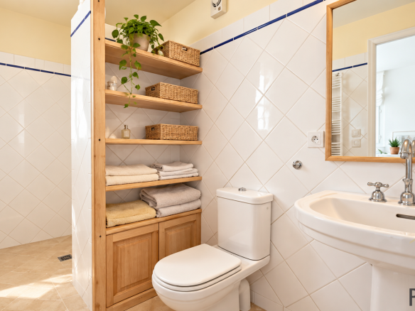 Bathroom with wooden furniture, sink and toilet in a house in Sergy.