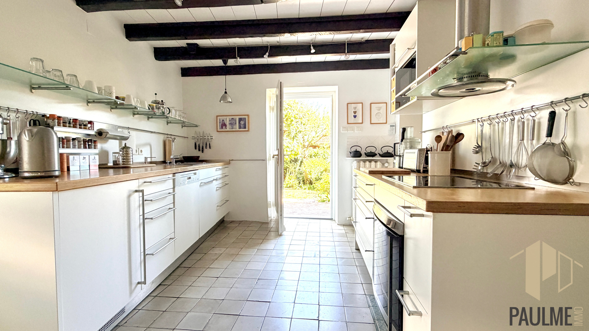 Kitchen of a stone house in Sergy Modern kitchen with wooden worktops and garden view, stone house in Sergy.