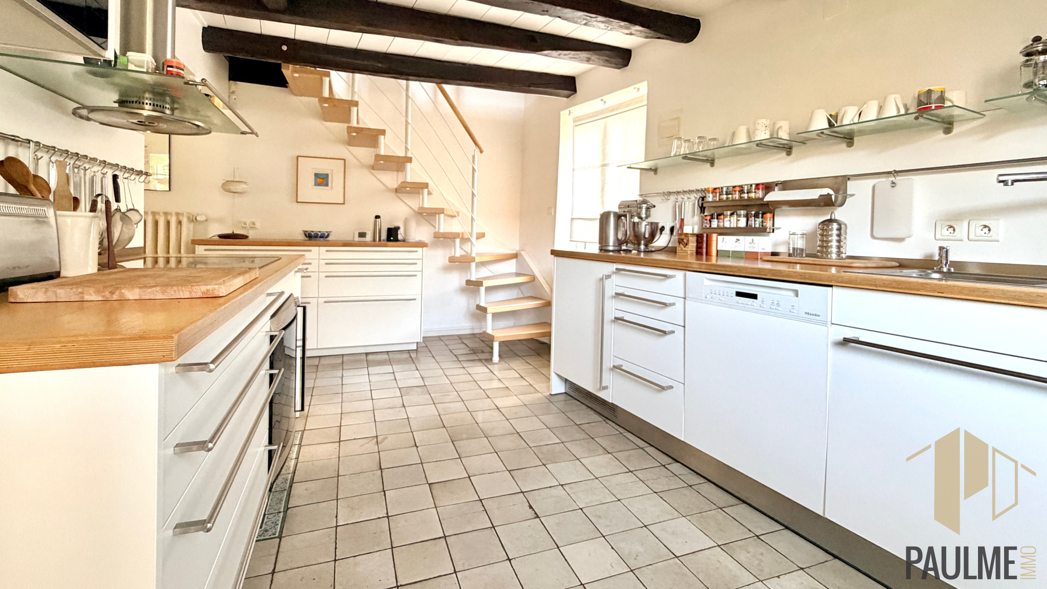 Kitchen of a stone house in Sergy Modern kitchen in a stone house with a wooden staircase, located in Sergy.