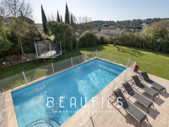 View of an architect-designed villa with swimming pool and terrace, surrounded by greenery in Nîmes.