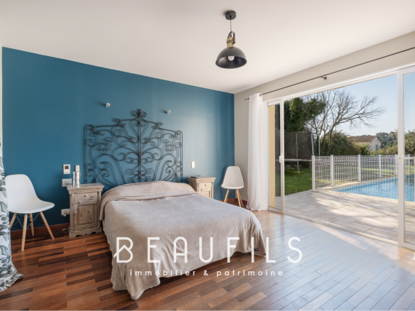 Bedroom in an architect-designed villa with access to the swimming pool, blue walls and wooden parquet flooring.