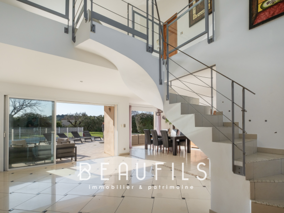 Interior of a modern architect-designed villa with a staircase and large windows.