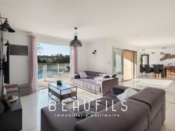 Interior of a modern architect-designed villa with living room and dining room opening onto the outside.