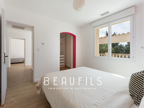 Room in a renovated neo-Provençal farmhouse in Saint-Gilles, with bed and bright windows.