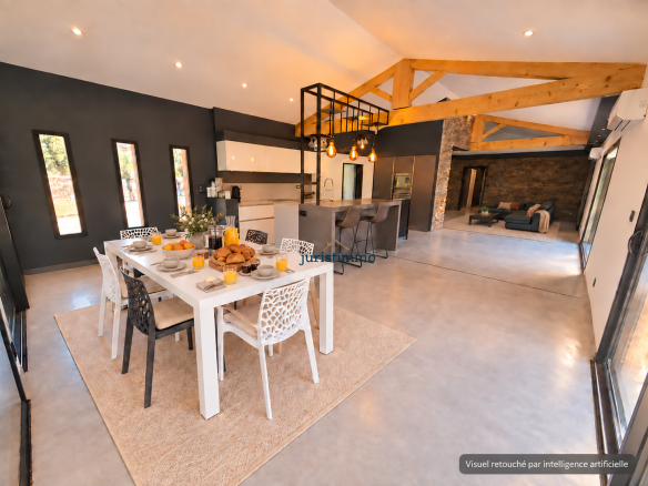 Intérieur d'une propriété moderne avec une salle à manger et une cuisine ouverte, décorée avec des éléments contemporains.
