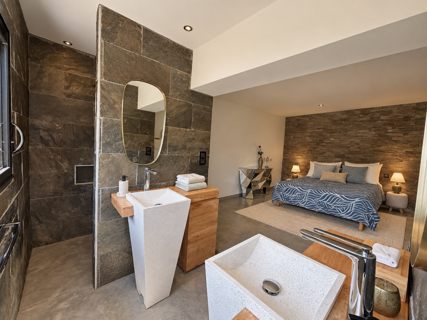 Chambre d’architecte avec salle de bain Chambre moderne avec salle de bain en pierre et mobilier en bois.