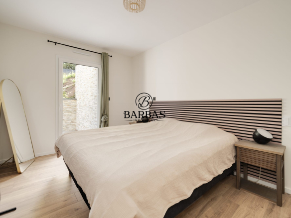 Chambre d'une maison d'architecte contemporaine avec lit et accès à l'extérieur.