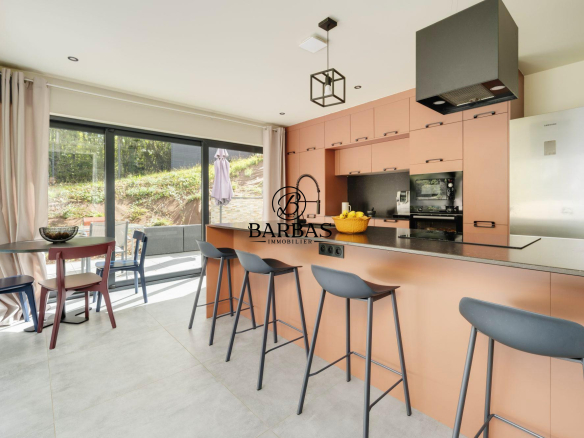 Cuisine moderne avec bar et coin repas dans une maison d'architecte à Vandoeuvre-lès-Nancy.