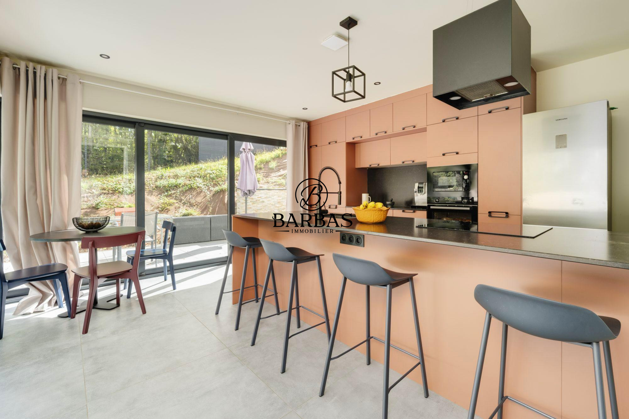 Cuisine moderne avec bar et coin repas dans une maison d'architecte à Vandoeuvre-lès-Nancy.