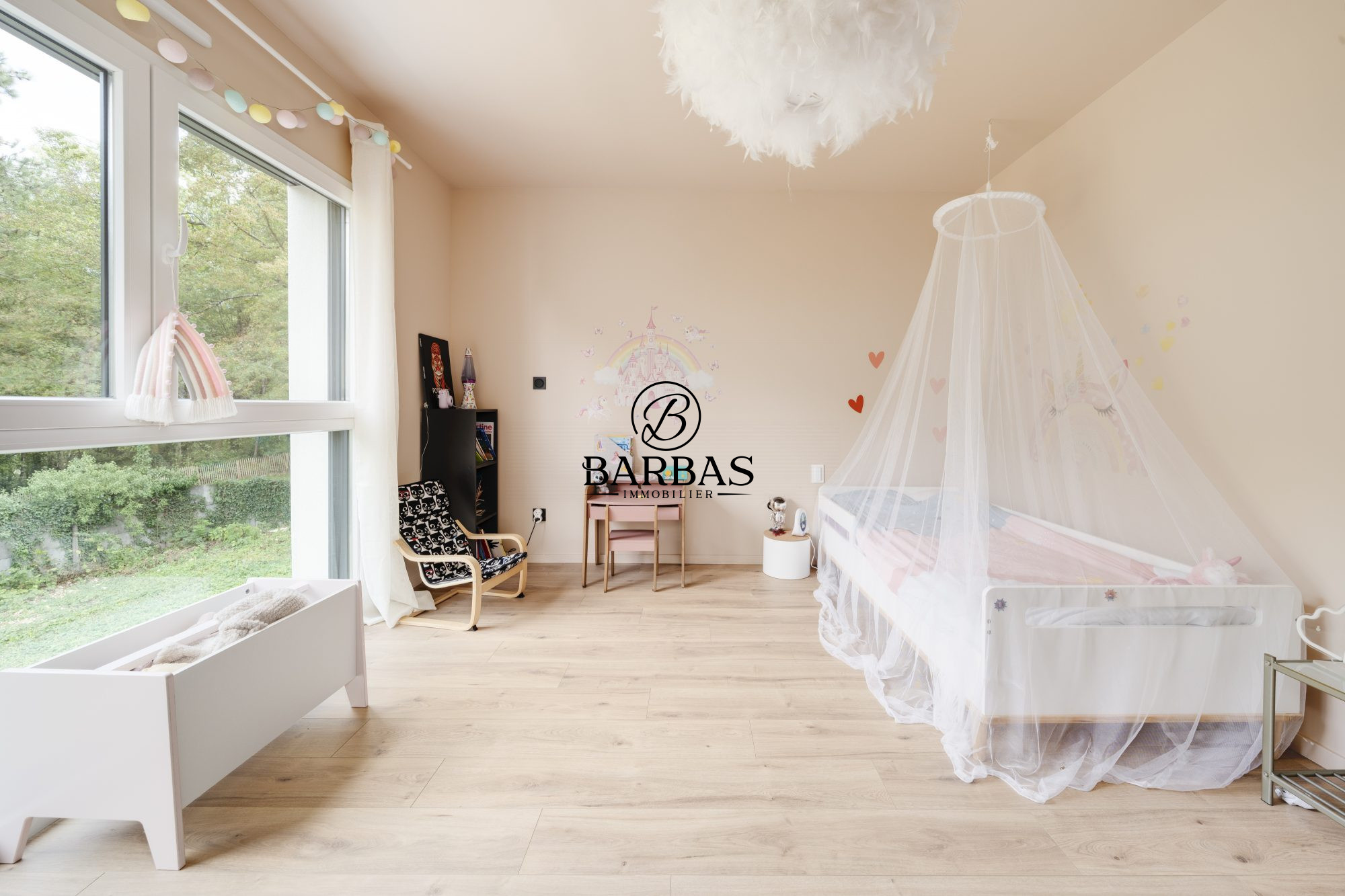 Chambre lumineuse avec lit bébé et décoration douce, fenêtres donnant sur la nature.