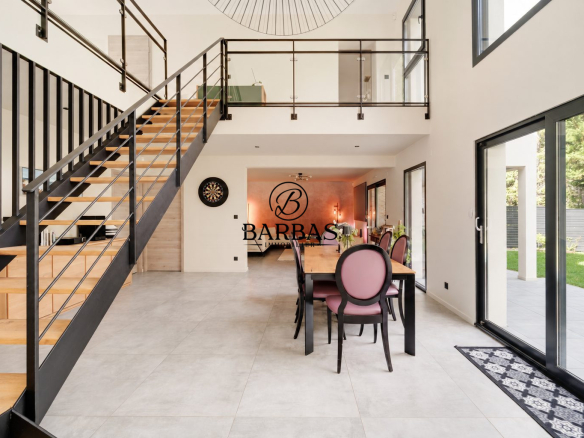 Intérieur d'une maison d'architecte moderne avec escalier et salle à manger.