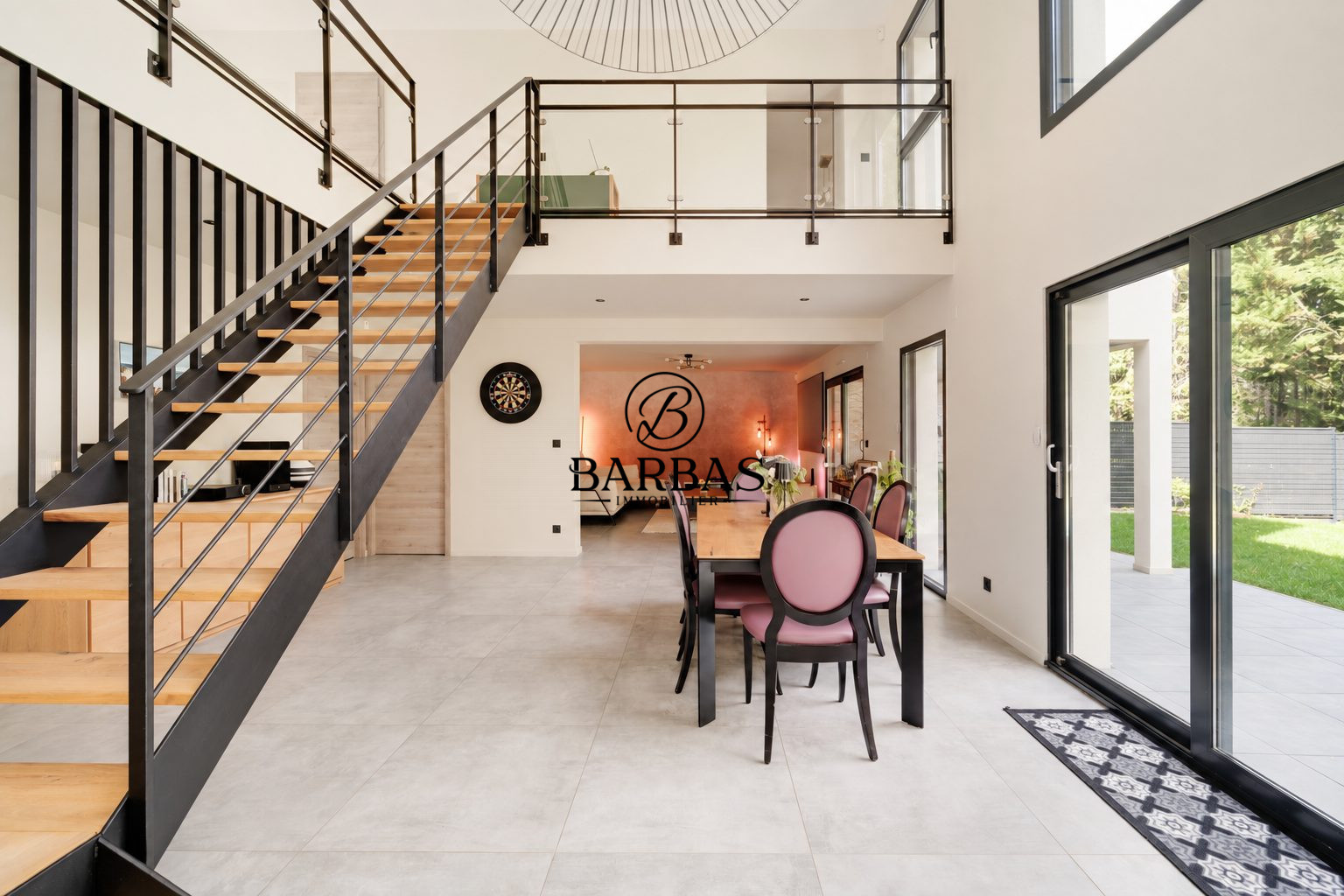 Intérieur d'une maison d'architecte moderne avec escalier et salle à manger.
