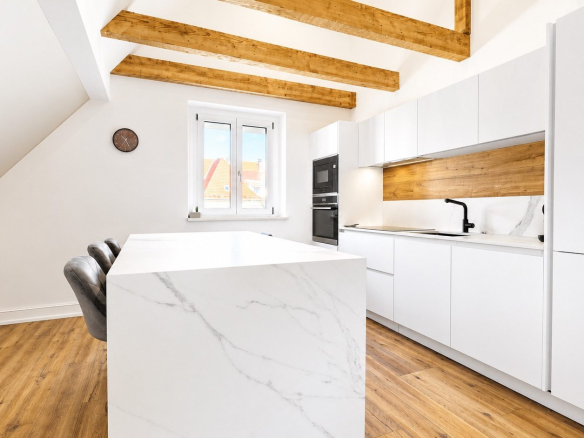 Cuisine moderne avec îlot central et équipements intégrés dans une maison rénovée à Munster.