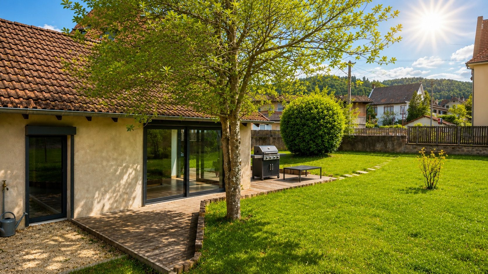 Jardin d’une maison à Munster Jardin d'une maison rénovée à Munster avec terrasse en bois et barbecue