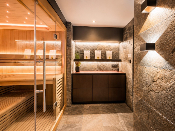 Intérieur d'un spa privatif avec sauna en bois et éclairage tamisé.