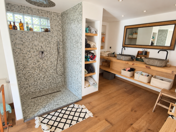 Salle de bains moderne avec douche à l'italienne et double vasque en bois.