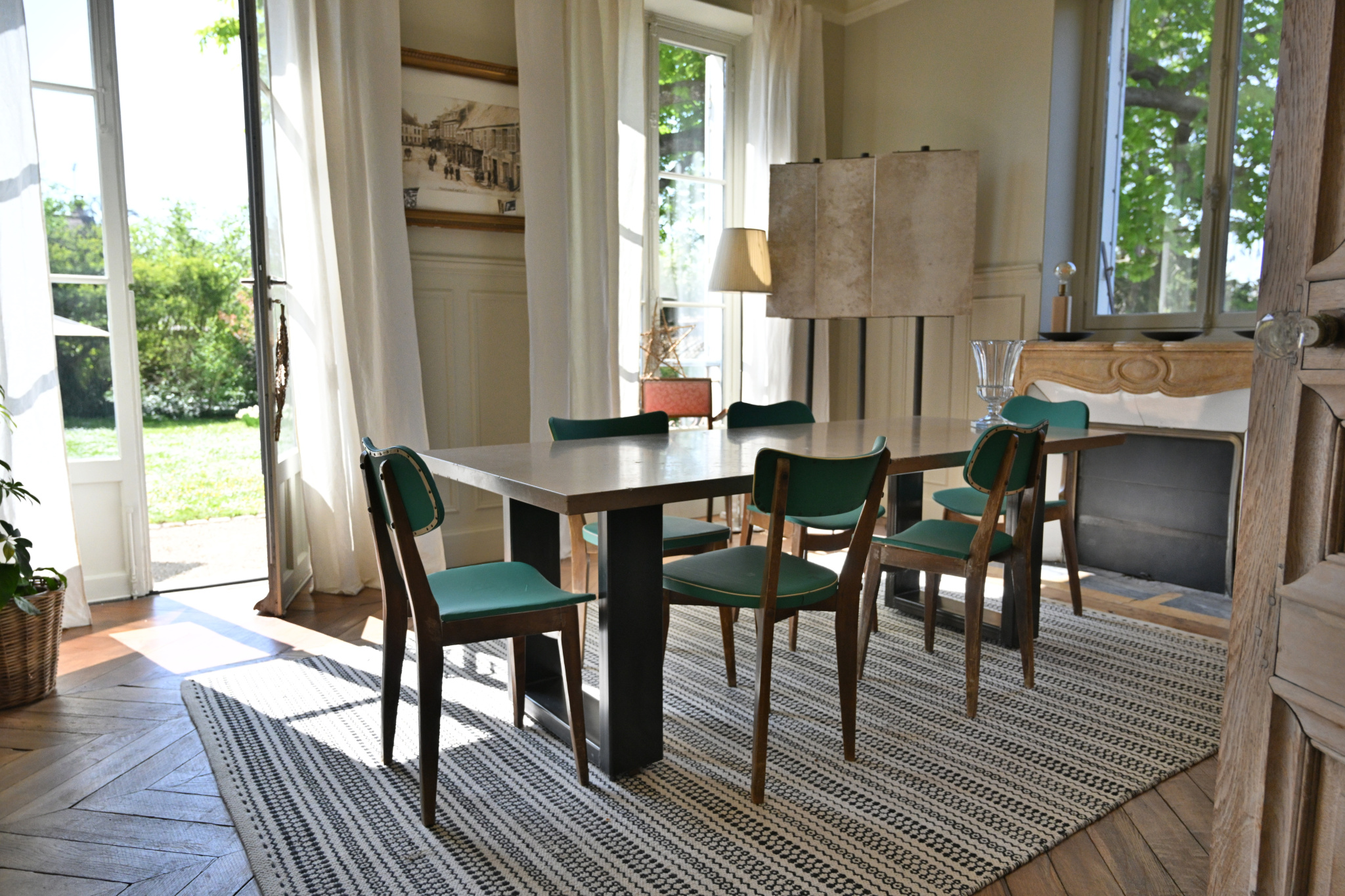 Salle à manger d’une maison de caractère à Étampes Salle à manger lumineuse avec table et chaises, fenêtres ouvertes sur jardin.