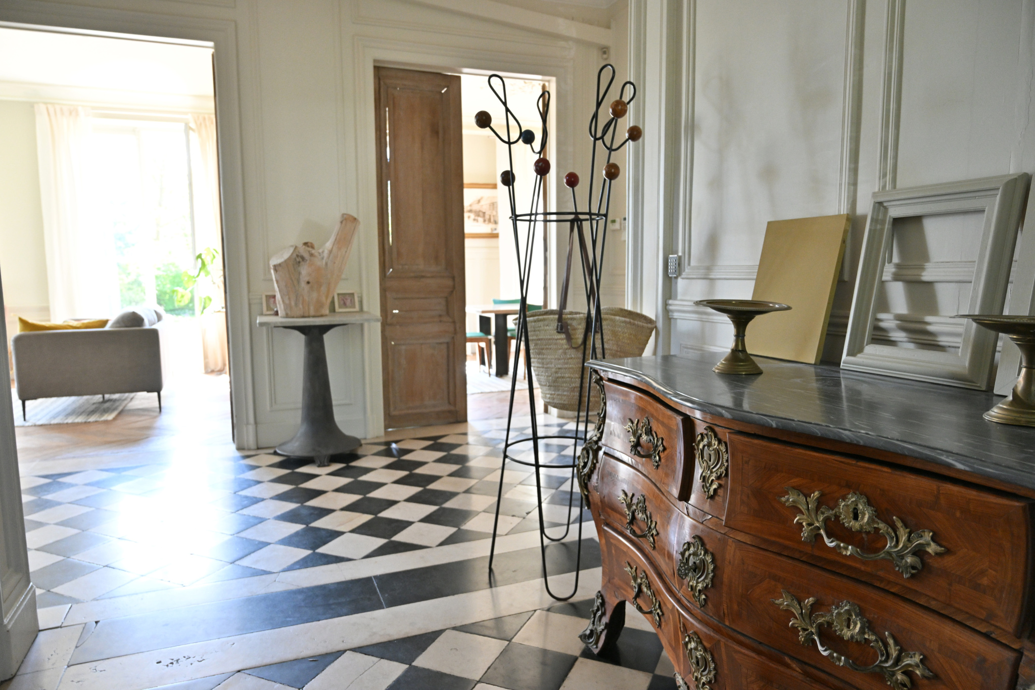Intérieur d’une maison de maître à Étampes Intérieur d'une maison de caractère avec un sol en damier, un meuble ancien et des murs élégants.