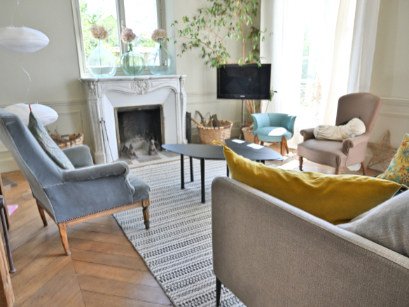 Intérieur d'une maison de caractère avec salon élégant, cheminée et mobilier raffiné.