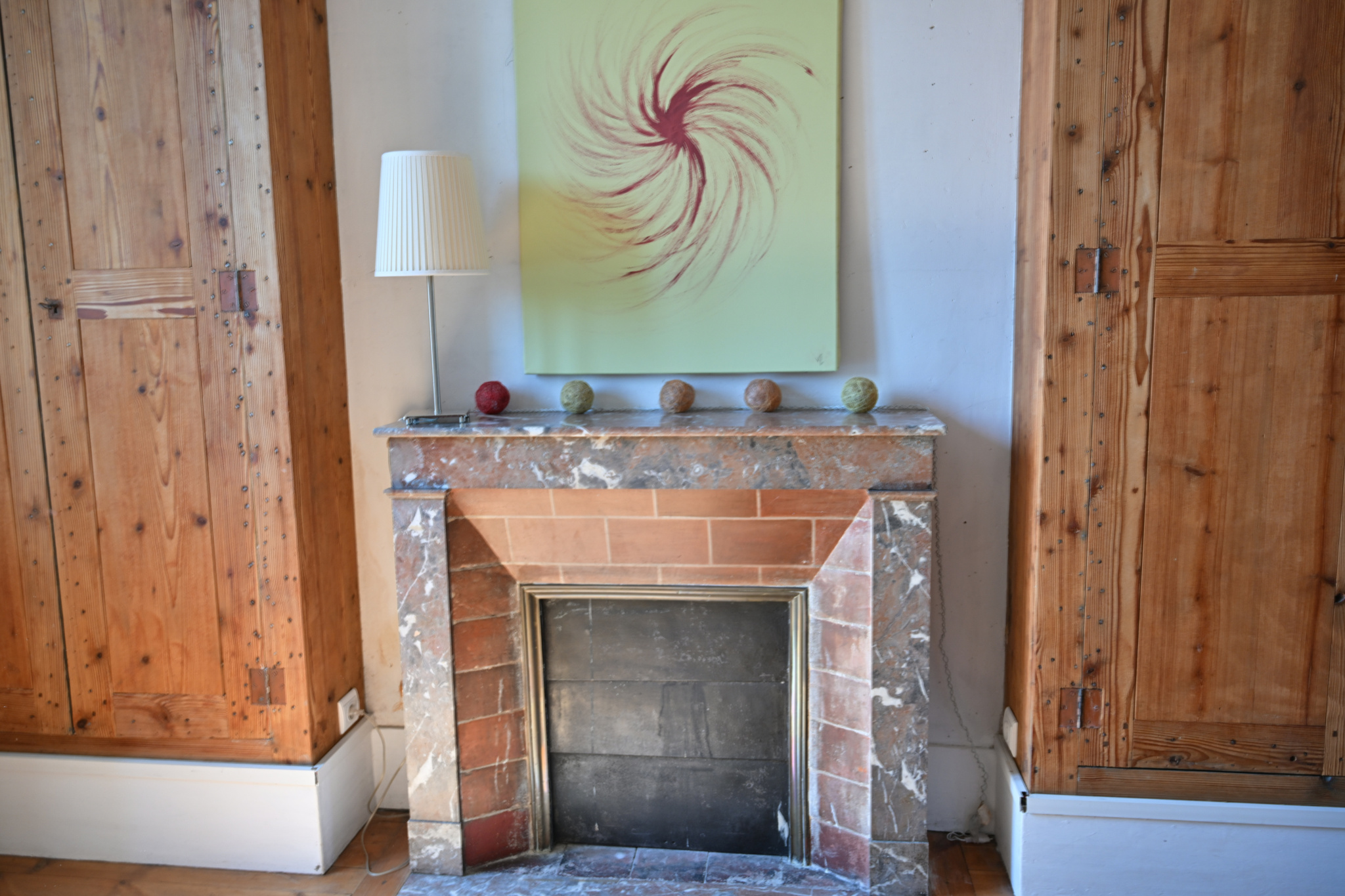 Intérieur d’une maison de caractère à Étampes Cheminée en marbre dans une maison de caractère avec murs en bois, décor minimaliste.
