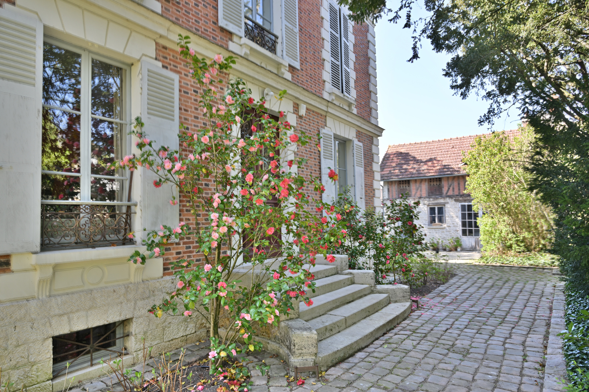 Maison de caractère à Étampes Entrée d'une maison de caractère avec des fleurs et des escaliers en pierre à Étampes.