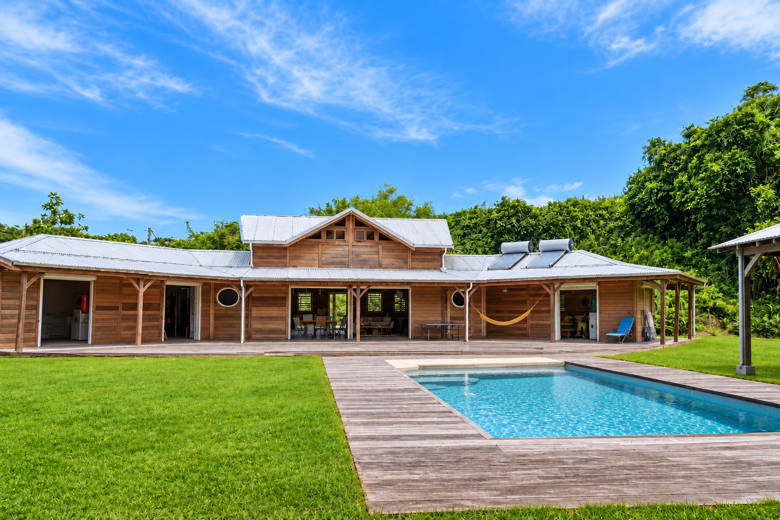 Maison en bois avec piscine et jardin, située à Goyave, à proximité de la plage.