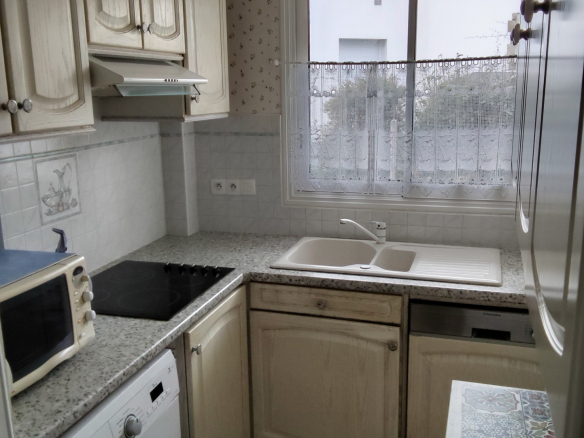 Kitchen of an apartment in Carnac with sink, hob and appliances.