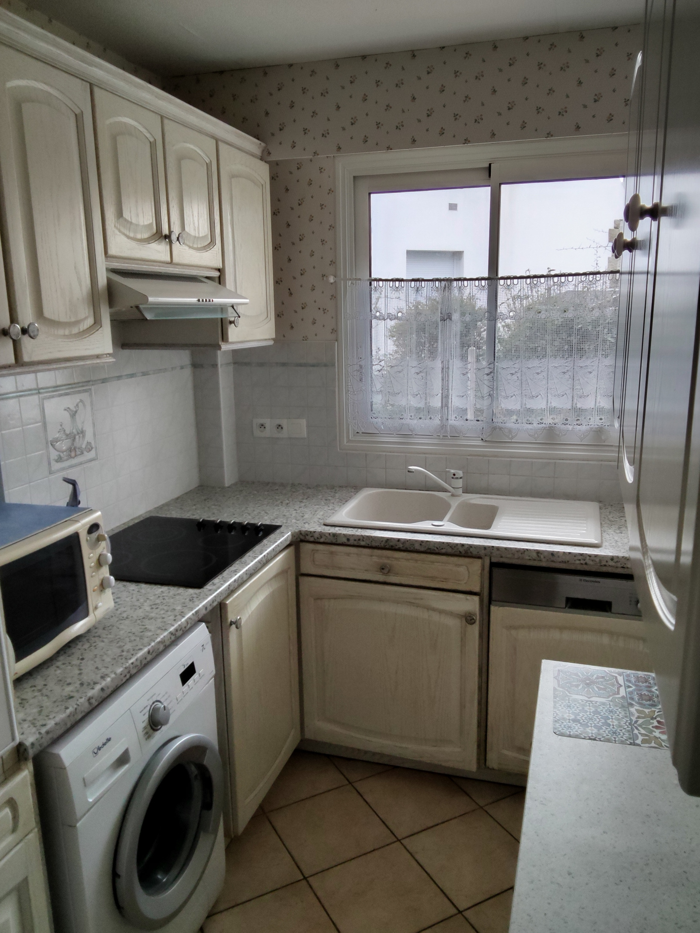 Kitchen of an apartment in Carnac with sink, hob and appliances.
