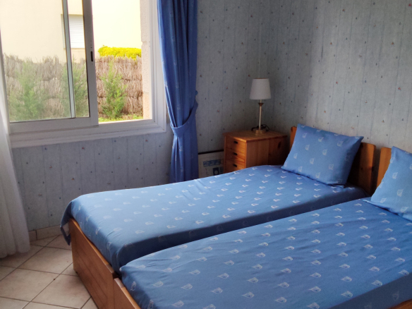Room with two twin beds and a window overlooking the outside.