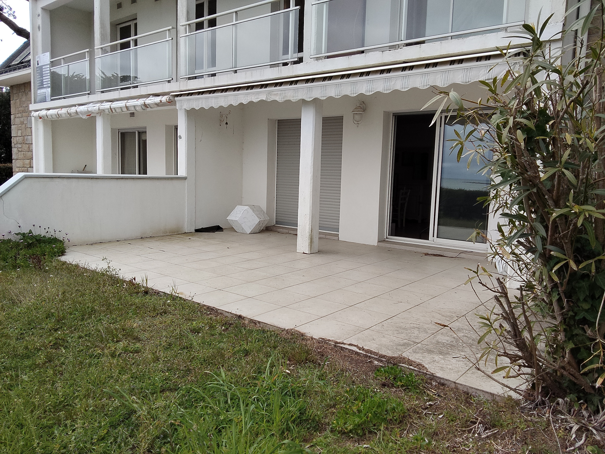 Apartment terrace with sea view in Carnac, surrounded by greenery.