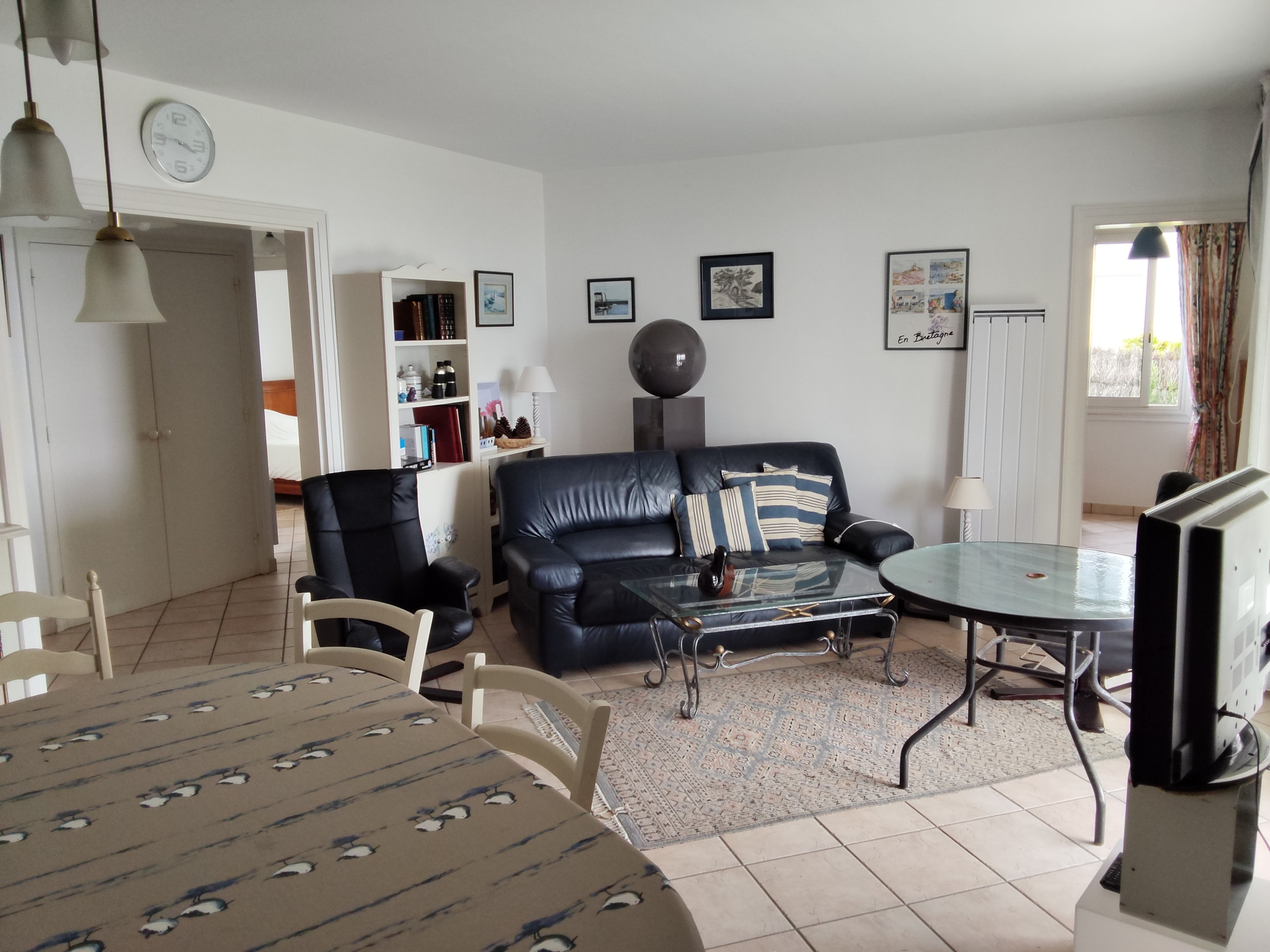 Interior of an apartment in Carnac with living room, table and chairs, and access to a garden.