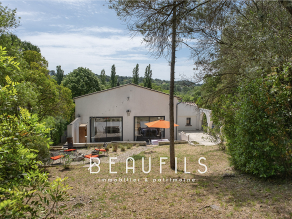Architect-designed villa surrounded by trees in Montferrier-sur-Lez, with terrace and outdoor furniture.