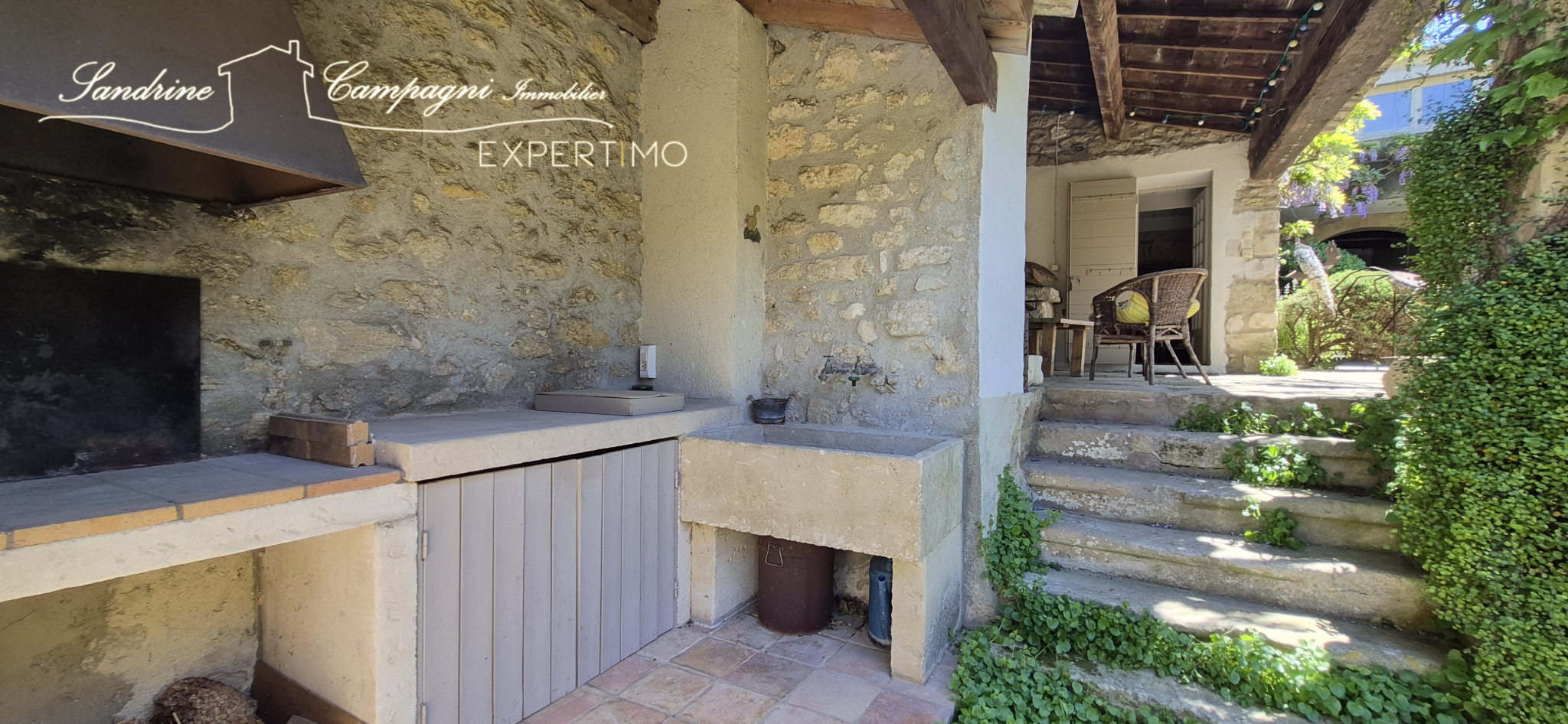 Outdoor kitchen at the farmhouse in Maubec Outdoor stone kitchen with barbecue and living area, in a restored farmhouse in Maubec.