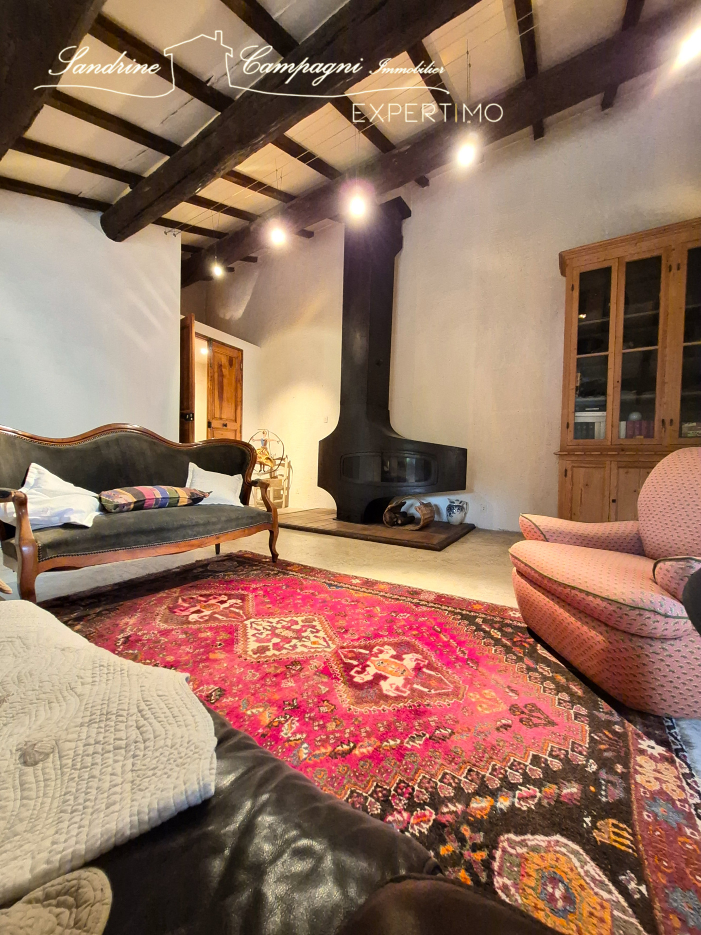 Interior of a restored farmhouse Interior of a farmhouse with fireplace, sofas and colorful rug.