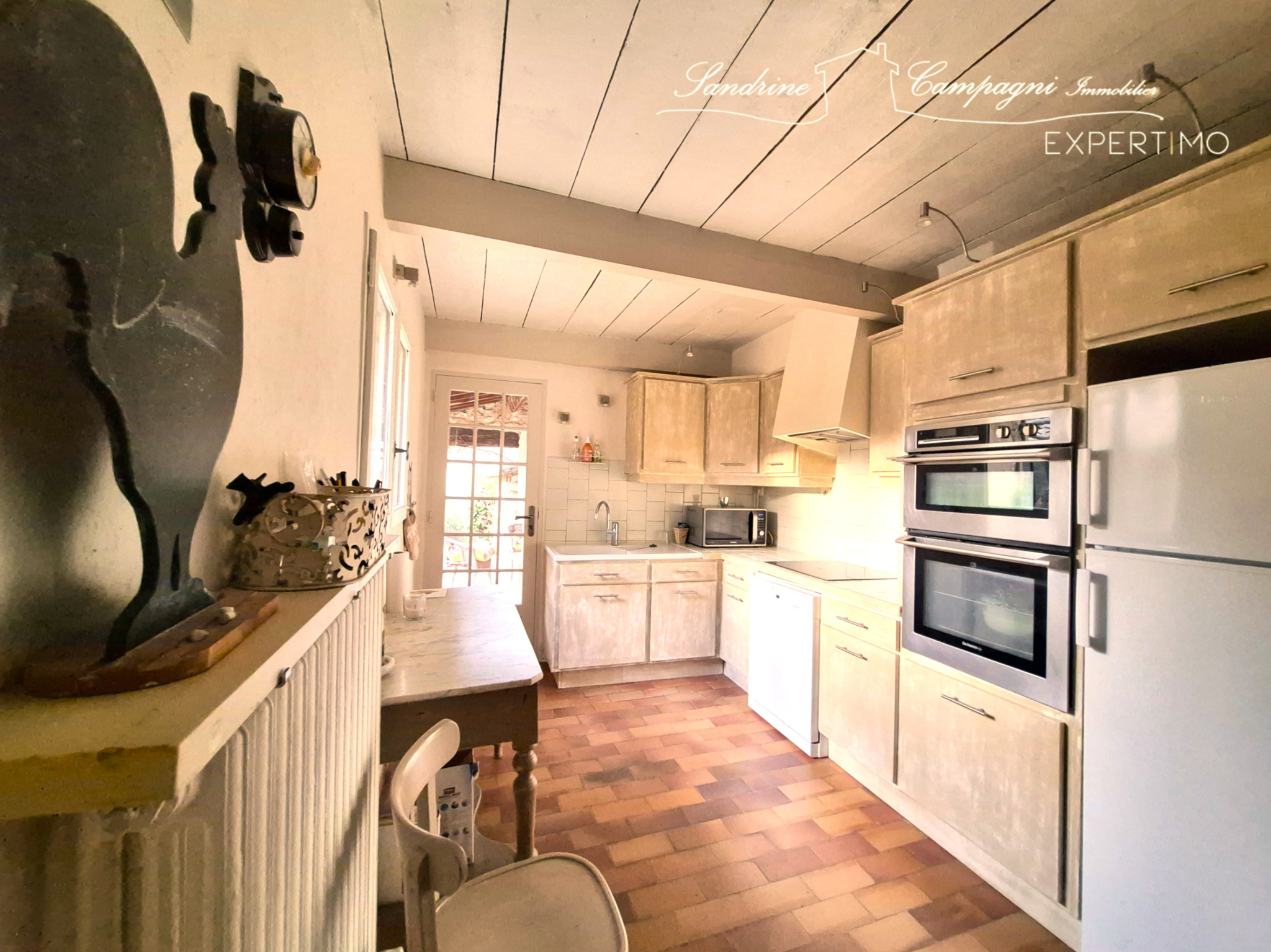 Kitchen of a renovated farmhouse in Maubec Kitchen in a renovated farmhouse with light-colored furniture and modern appliances.