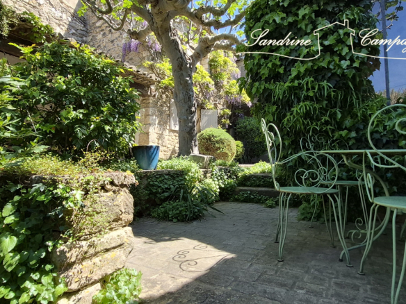 Landscaped garden with wrought iron furniture in a restored farmhouse in Maubec.