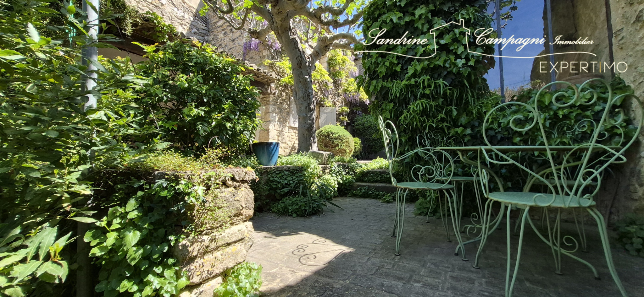 Garden of a farmhouse in Maubec Landscaped garden with wrought iron furniture in a restored farmhouse in Maubec.