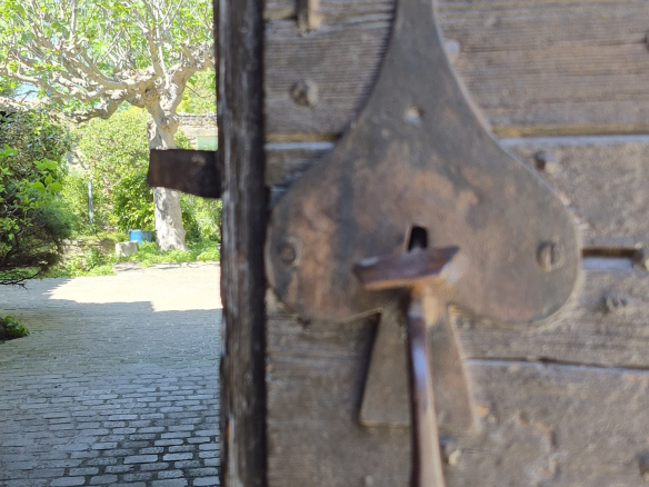Close-up of a heart-shaped metal lock on a wooden door.